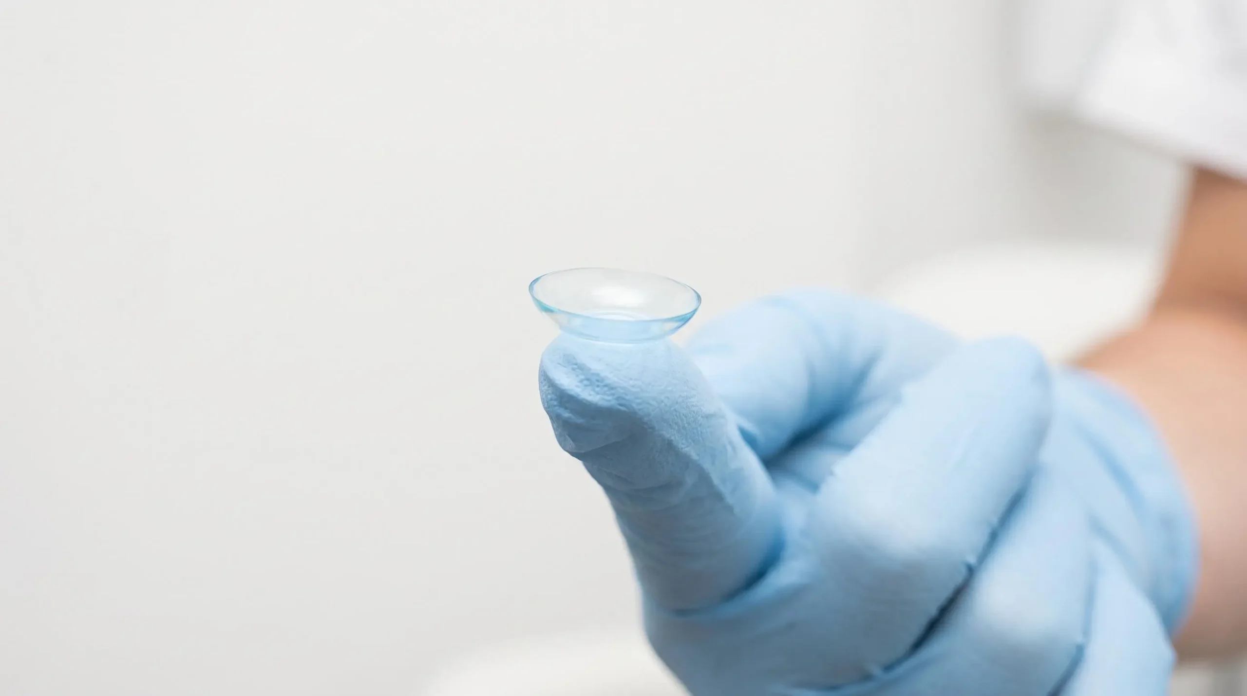 Lentille de contact d'orthokératologie pour le contrôle de la myopie tenue sur le bout du doigt d'un professionnel de santé